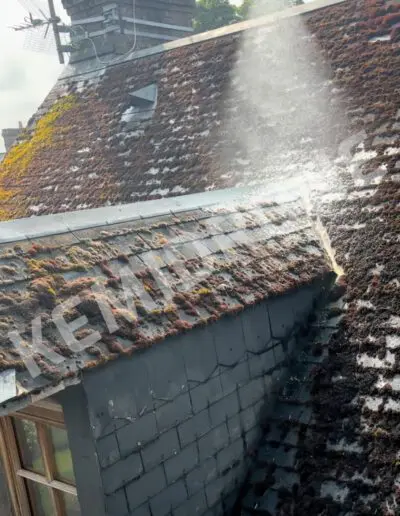 Toit en ardoise avec mousse, nettoyage en cours.