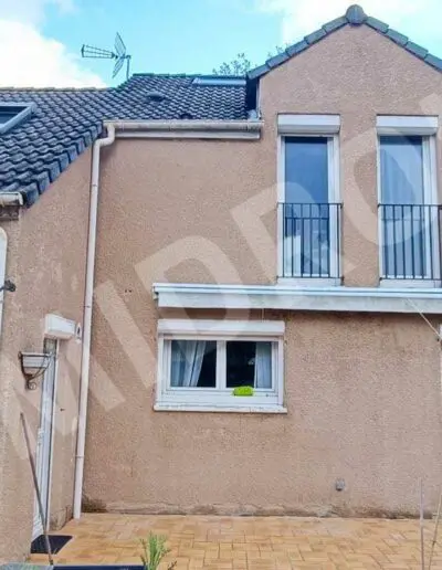 Façade d'une maison avec terrasse carrelée.