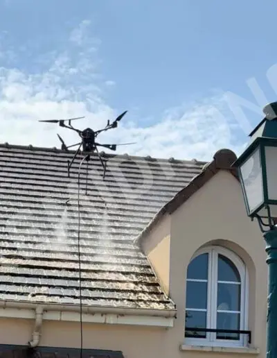 Drone nettoyant un toit en tuiles.