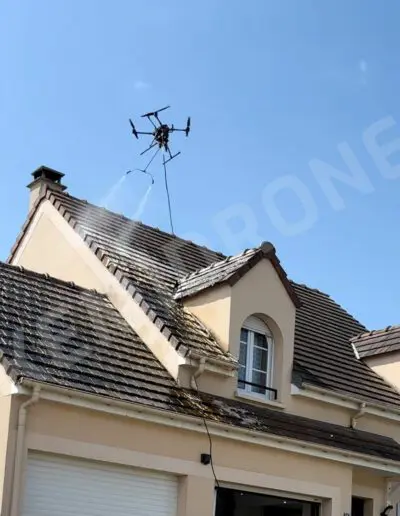 Drone nettoyant la toiture d'une maison.