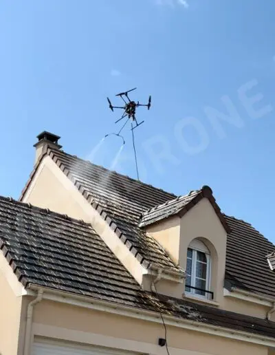 Drone nettoyant un toit avec de l'eau.