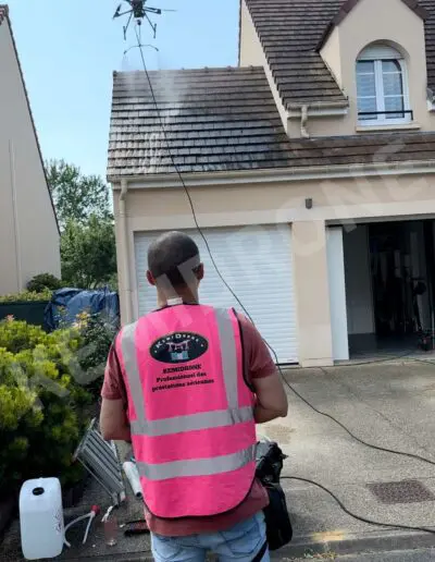 Drone nettoyant toiture d'une maison.