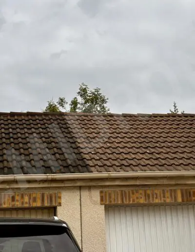 Toit en tuiles brunes sous ciel nuageux.